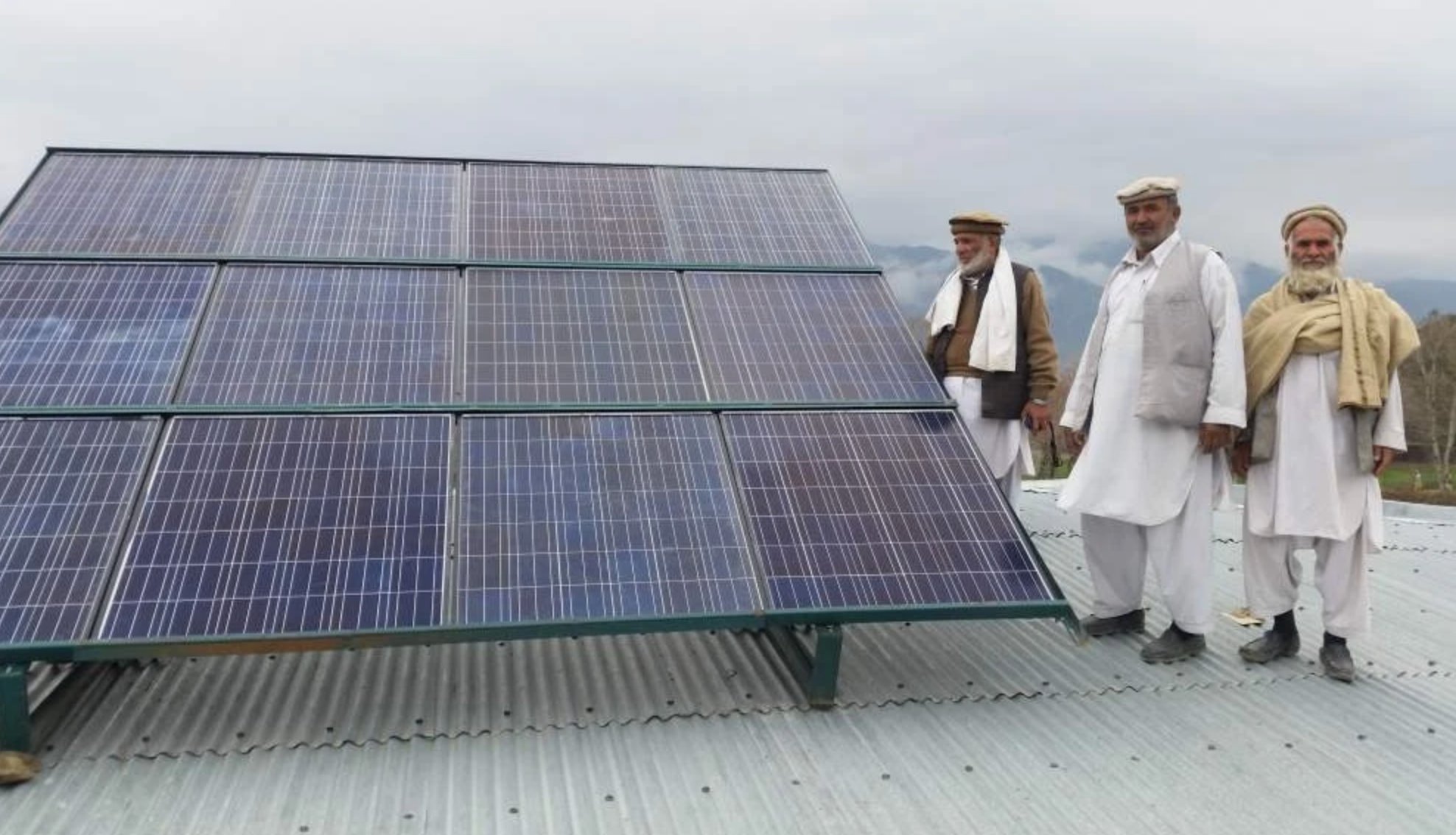 Three community elders with rooftop solar panels