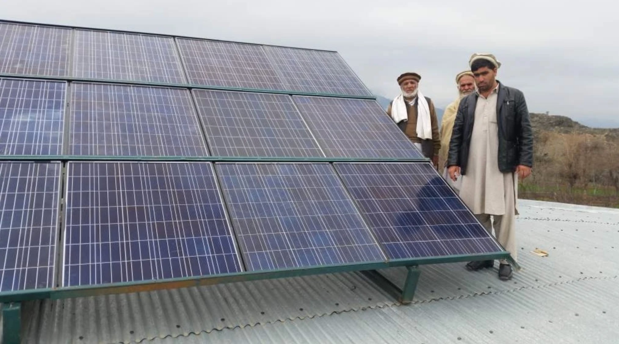 Community members inspecting completed solar installation