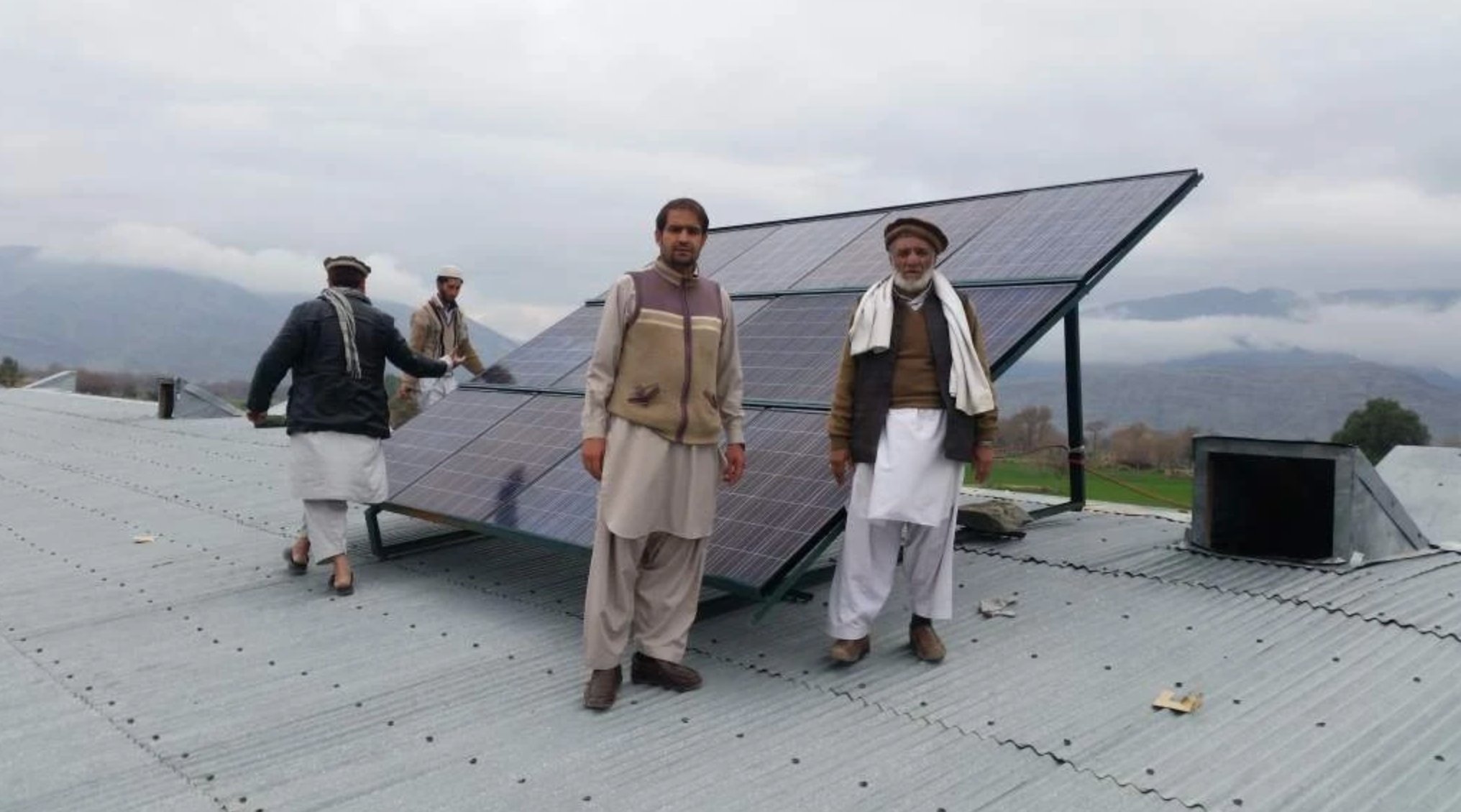 Team installing solar panels on school rooftop